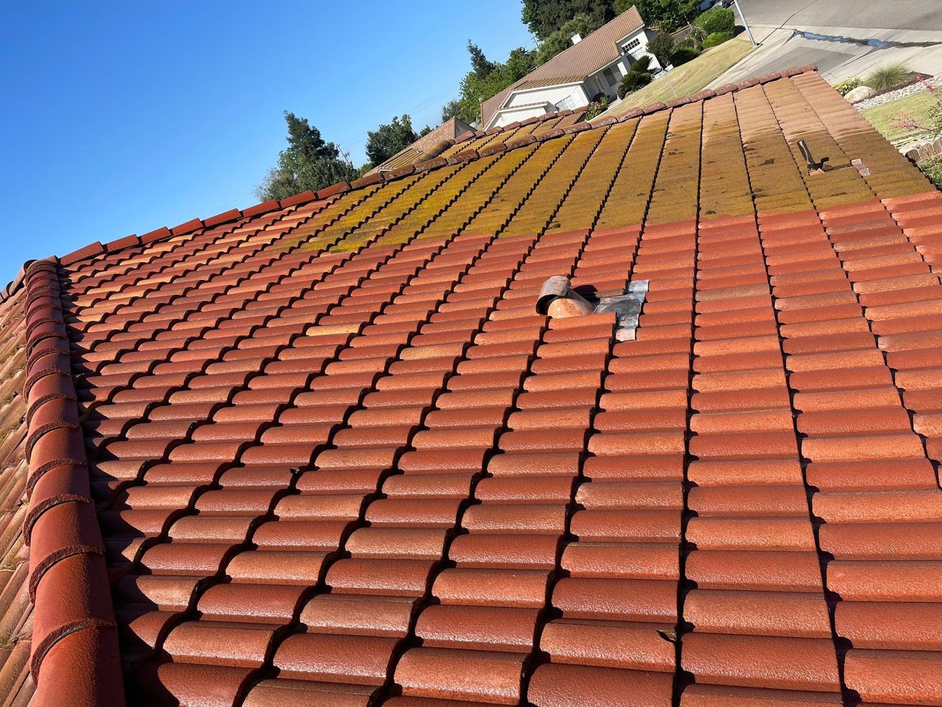 Tile roof mid-clean showing before and after